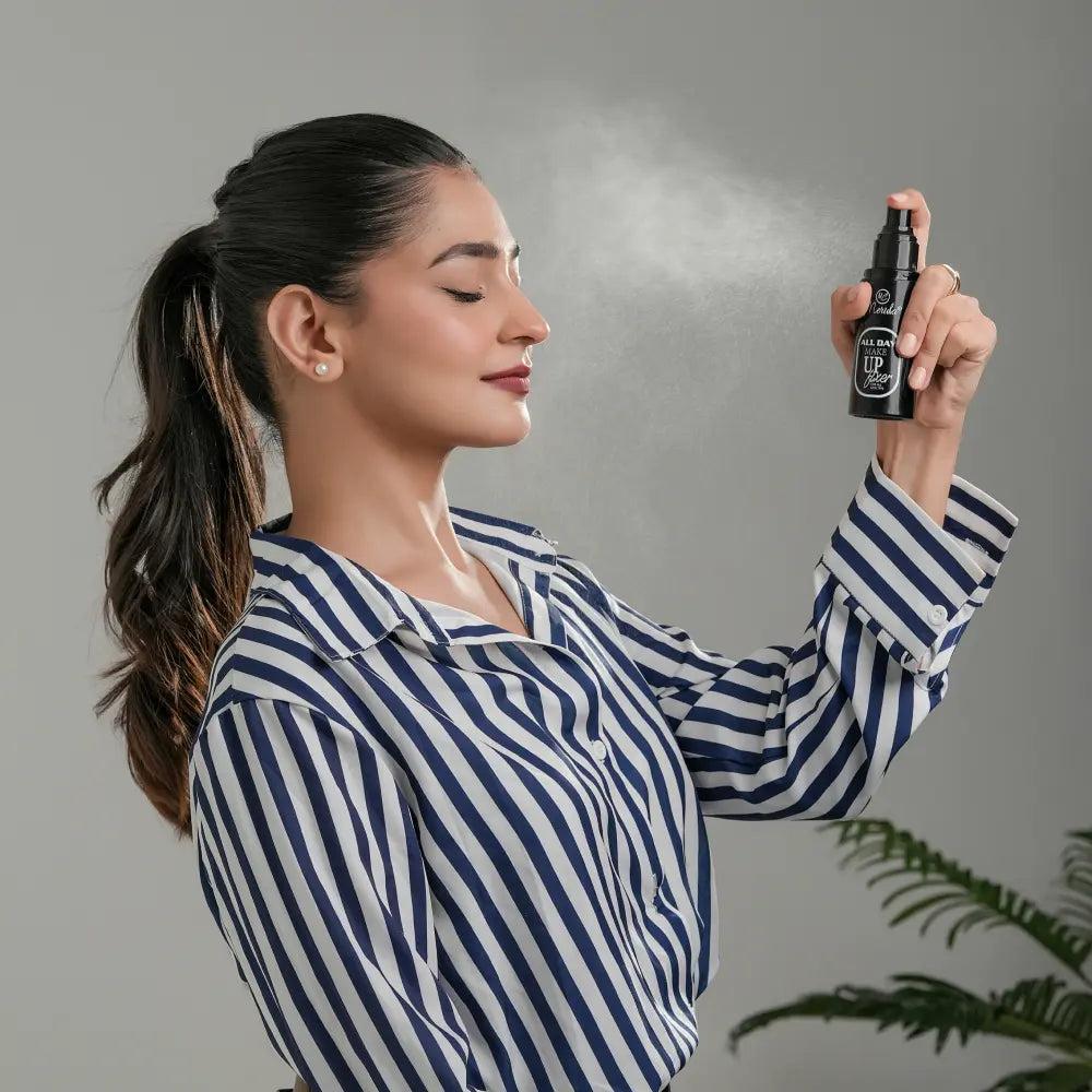 Woman spraying Merida All Day Makeup Fixer setting spray